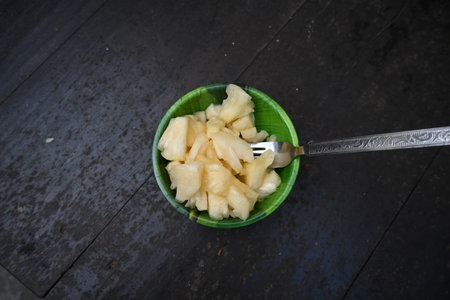 Pineapple or Ananas comosus slices on black background. It is aÂ tropical plantÂ with an edible fruit. It is plant in the familyÂ Bromeliaceae. Pineapple pieces in a bowl ready to eatの写真素材