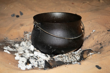 A South African Potjiekos pot standing in a hot BBQ in the UAE desert