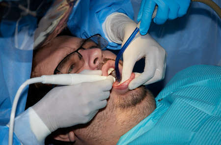A man with a slight beard undergoing a dental procedureの写真素材