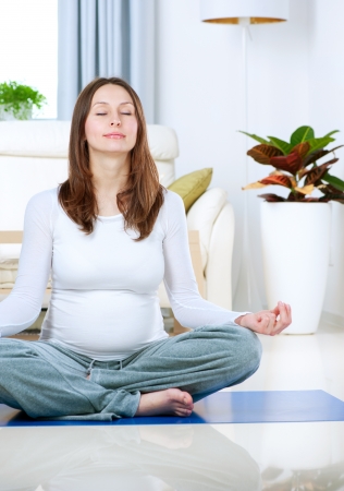 Beautiful Pregnant Woman Doing Yoga at Homeの写真素材