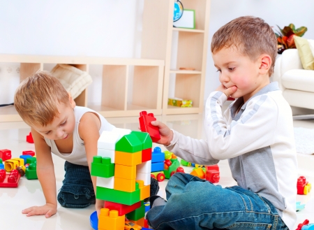 Children Boys playing with construction set on the floor の写真素材