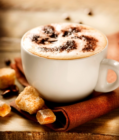 A cup of coffee or hot chocolate and female feet with socks on.. A cup of coffee or hot chocolate and female feet with socks on..