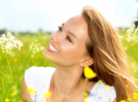 Beauty Girl in the Meadow lying on Green Grass with wild Flowers の写真素材