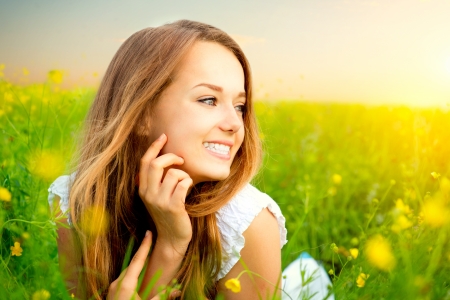 Beauty Girl in the Meadow lying on Green Grass の写真素材
