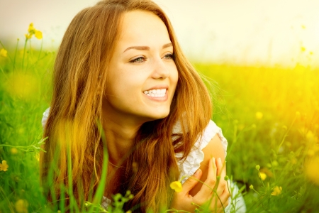 Beauty Girl in the Meadow lying on Green Grass の写真素材