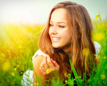 Beauty Girl in the Meadow lying on Green Grass の写真素材