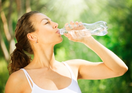 Healthy and Sporty Young Woman Drinking Water from the bottle