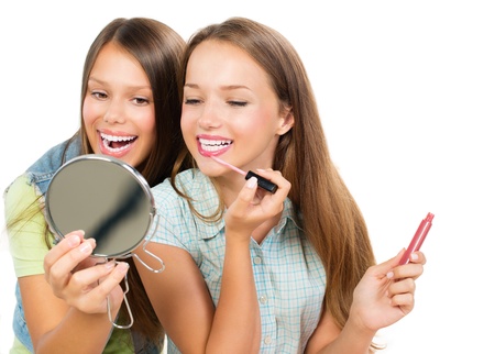 Pretty Teenage Girls Applying Make up and Looking in the Mirror の写真素材