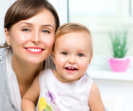 Happy Smiling Mother and Baby kissing and hugging at Homeの写真素材