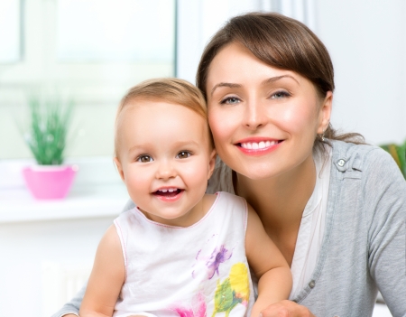 Happy Smiling Mother and Baby kissing and hugging at Homeの写真素材