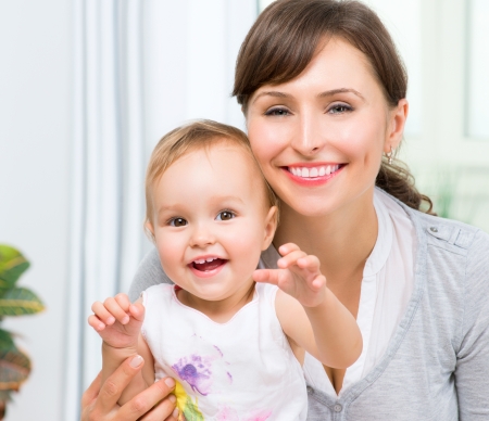 Happy Smiling Mother and Baby kissing and hugging at Homeの写真素材
