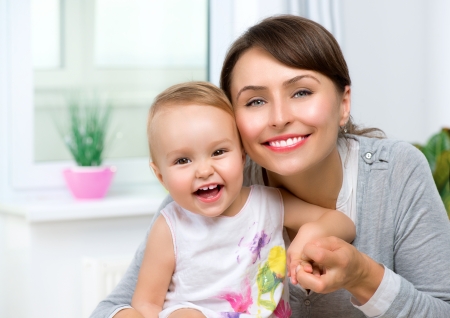 Happy Smiling Mother and Baby kissing and hugging at Homeの写真素材