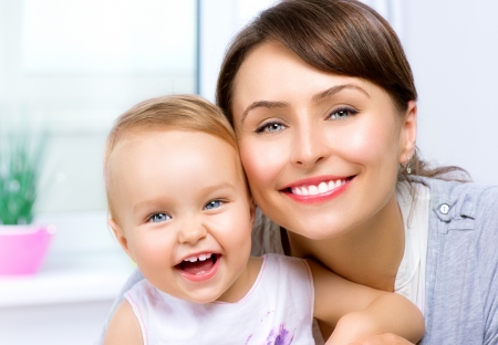 Happy Smiling Mother and Baby kissing and hugging at Home の写真素材