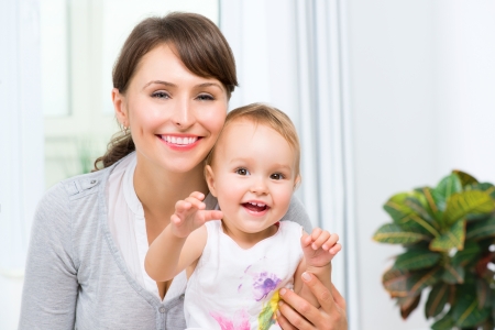 Happy Smiling Mother and Baby kissing and hugging at Home の写真素材