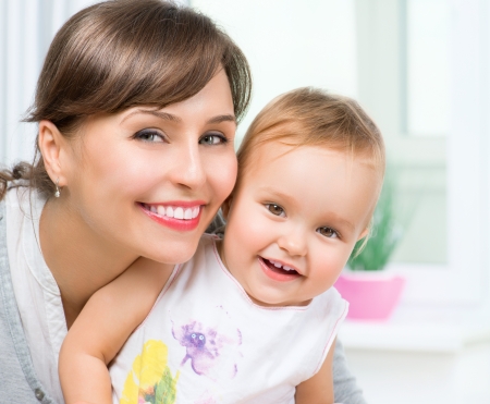 Happy Smiling Mother and Baby kissing and hugging at Home の写真素材