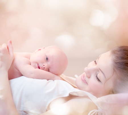 Happy Mother and her Newborn Baby Kissing and hugging Happy Mother and her Newborn Baby Kissing and hugging