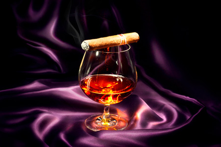 Cognac and cigar  Glass of brandy over dark backgroundの写真素材