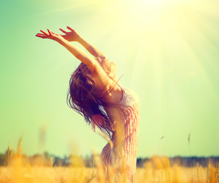 Beauty girl outdoors enjoying nature on wheat fieldの販売画像