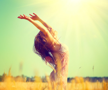 Beauty girl outdoors enjoying nature on wheat field