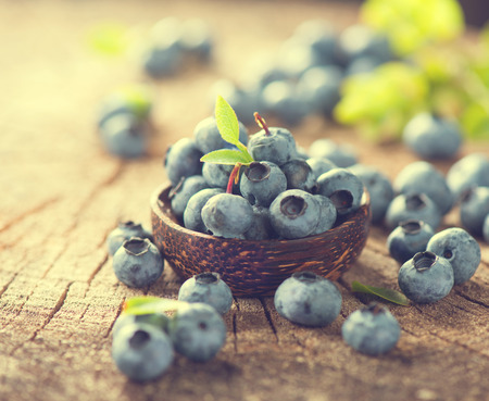 Freshly picked Blueberries in bowl on wooden table. Blueberry closeup. Concept of healthy eating. Bilberries in Vintage tonedの写真素材