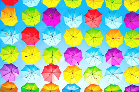 Hanging multicolored umbrellas over blue skyの写真素材