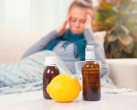 Sick young woman lying on the sofa at home. Fluの写真素材