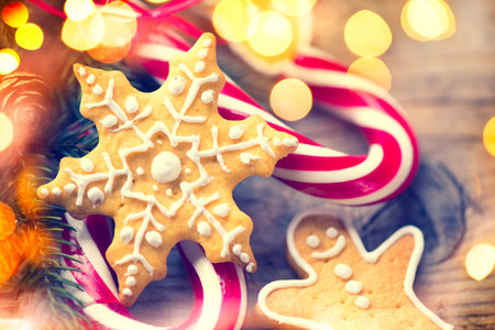 Christmas gingerbread homemade cookies and candy canes over wooden background