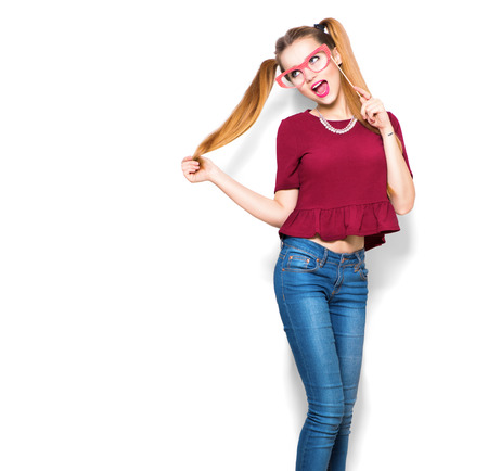 Surprised teenage girl holding funny paper glasses on stickの写真素材