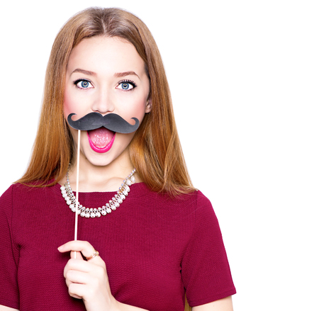 Surprised teenage gil holding funny mustache on stickの写真素材
