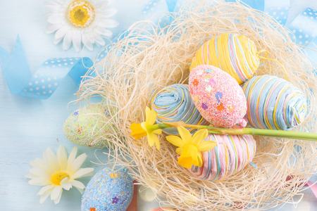 Easter eggs in the nest with spring flowers over wooden backgroundの写真素材