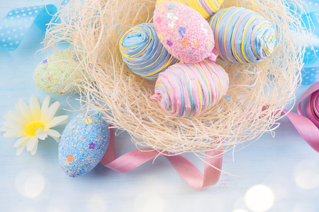 Easter eggs in the nest with spring flowers over wooden backgroundの写真素材