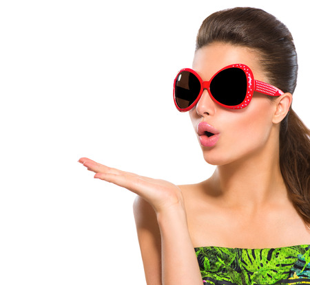 Fashion model girl wearing red sunglasses showing empty copyspace on open handの写真素材