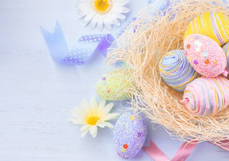 Easter eggs in the nest with spring flowers over wooden backgroundの写真素材