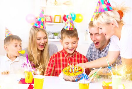 Birthday. Little boy blows out candles on birthday cakeの写真素材