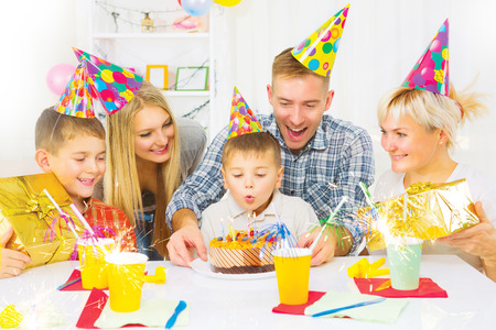 Birthday. Little boy blows out candles on birthday cakeの写真素材