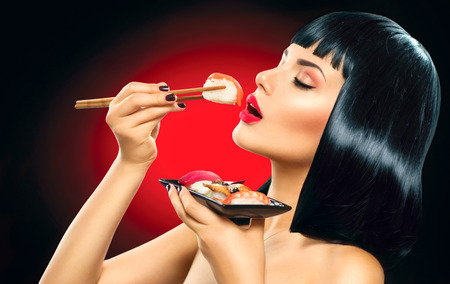 Sushi. Fashion art portrait of beauty model girl eating sushiの写真素材