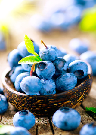 Freshly picked juicy blueberries in wooden bowlの写真素材