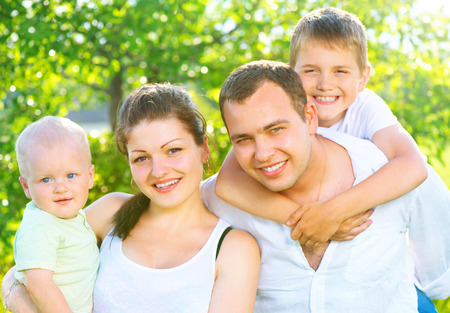 Happy joyful young family together in summer parkの写真素材
