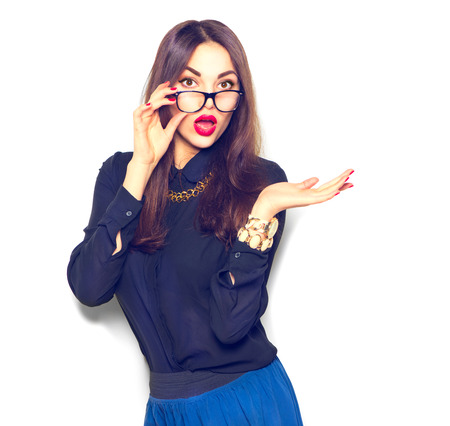 Surprised girl wearing glasses and showing empty copy space on open hand palm for textの写真素材