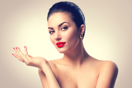 Brunette spa girl showing empty copy space on the open hand palmの写真素材