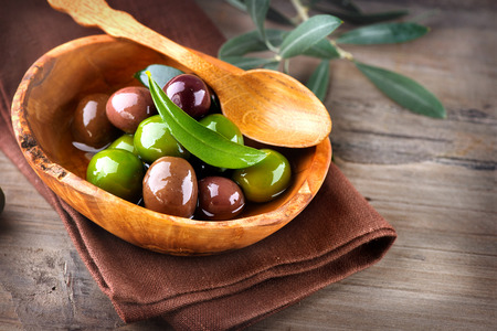 Olives and olive oil on wooden rustic tableの写真素材