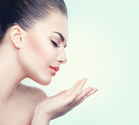 Beauty spa woman with perfect skin showing empty copy space on the open hand palmの写真素材