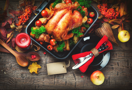 Thanksgiving table served with turkey, decorated with bright autumn leavesの写真素材