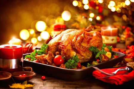 Thanksgiving table served with turkey, decorated with bright autumn leaves