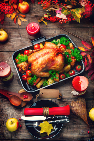 Thanksgiving table served with turkey, decorated with bright autumn leavesの写真素材