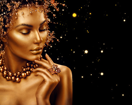 Beauty fashion model girl with golden skin, makeup and hairstyle isolated on black backgroundの写真素材