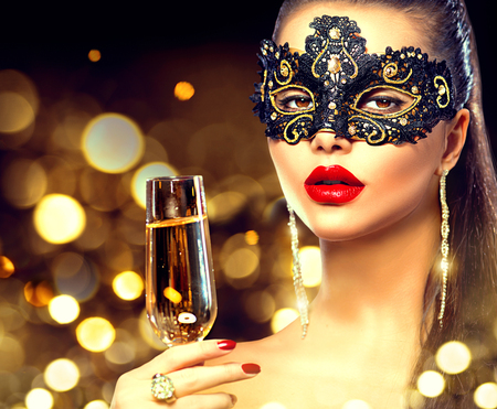 Sexy model woman with glass of champagne wearing venetian masquerade maskの写真素材