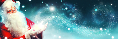 Portrait of happy Santa Claus with magic light in his handsの写真素材