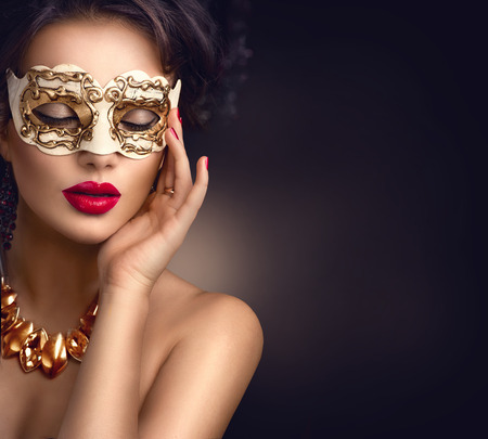 Beauty model woman wearing venetian masquerade carnival mask at party. Christmas and New Year celebrationの写真素材