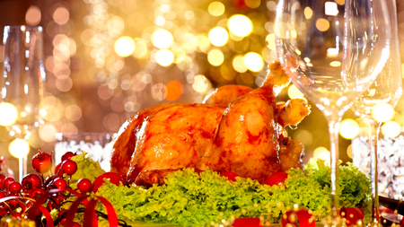 Holiday decorated table, Christmas tree, champagne and roasted turkeyの写真素材